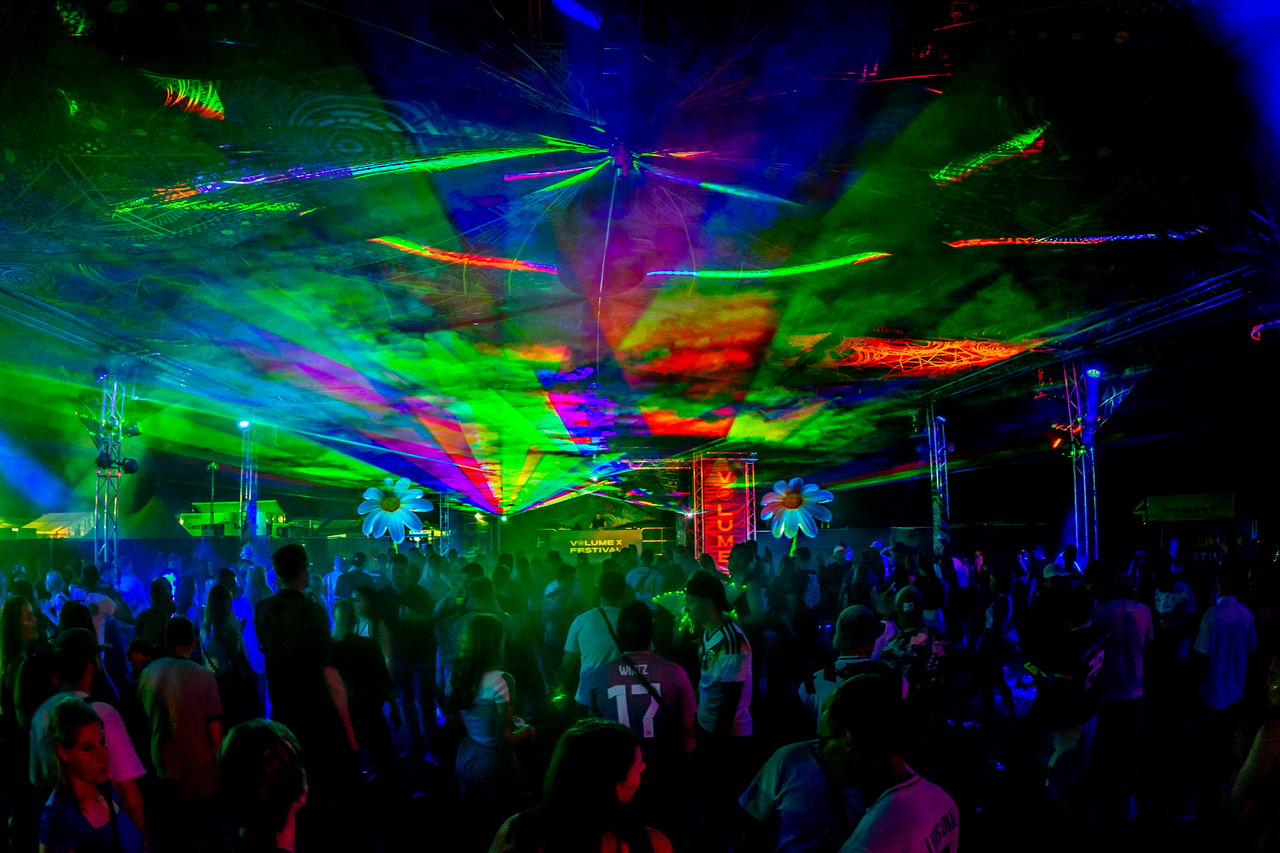 XPedition Stage: farverige lasere og psykedelisk dekoration over den dansende menneskemængde.