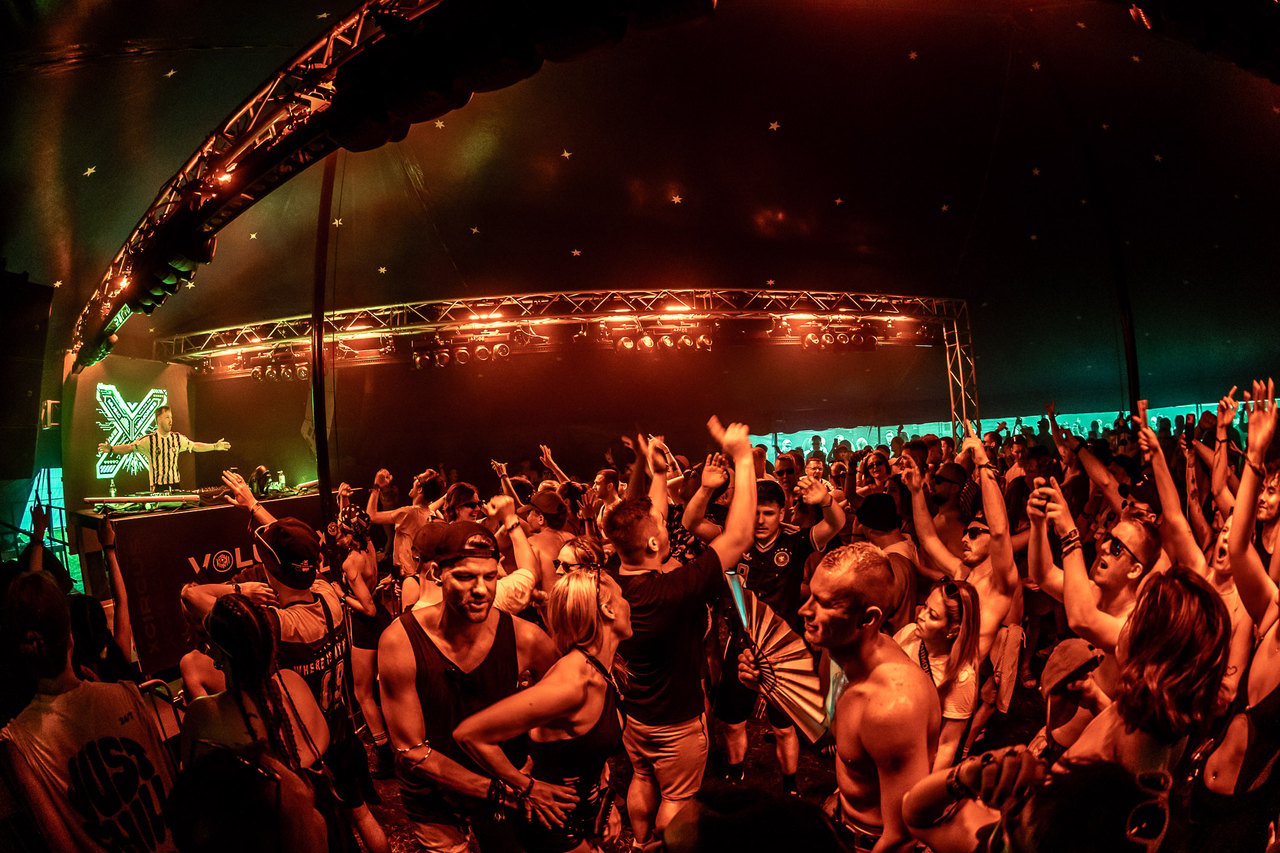 XCircus Stage i cirkusteltet: DJ ved pulten, festende publikum under teltets kuppel.